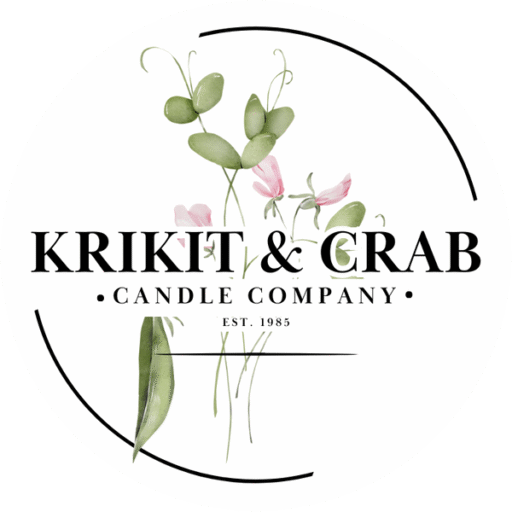 "Logo for Krikit & Crab Candle Company featuring elegant black serif text over a watercolor illustration of green leaves and soft pink flowers. The design is enclosed in a minimalistic circular frame with black accents and includes the text 'Candle Company' and 'Est. 1985' beneath the main brand name."